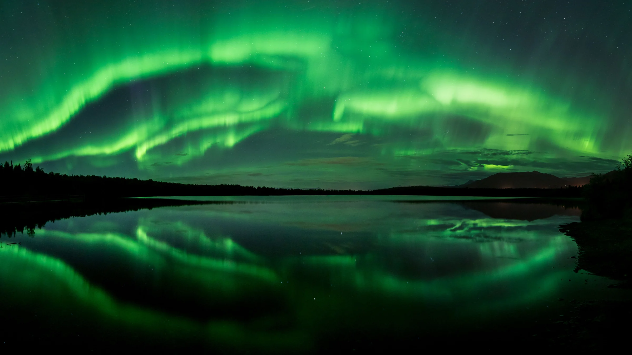 Aurora Borealis reflected across a dark lake