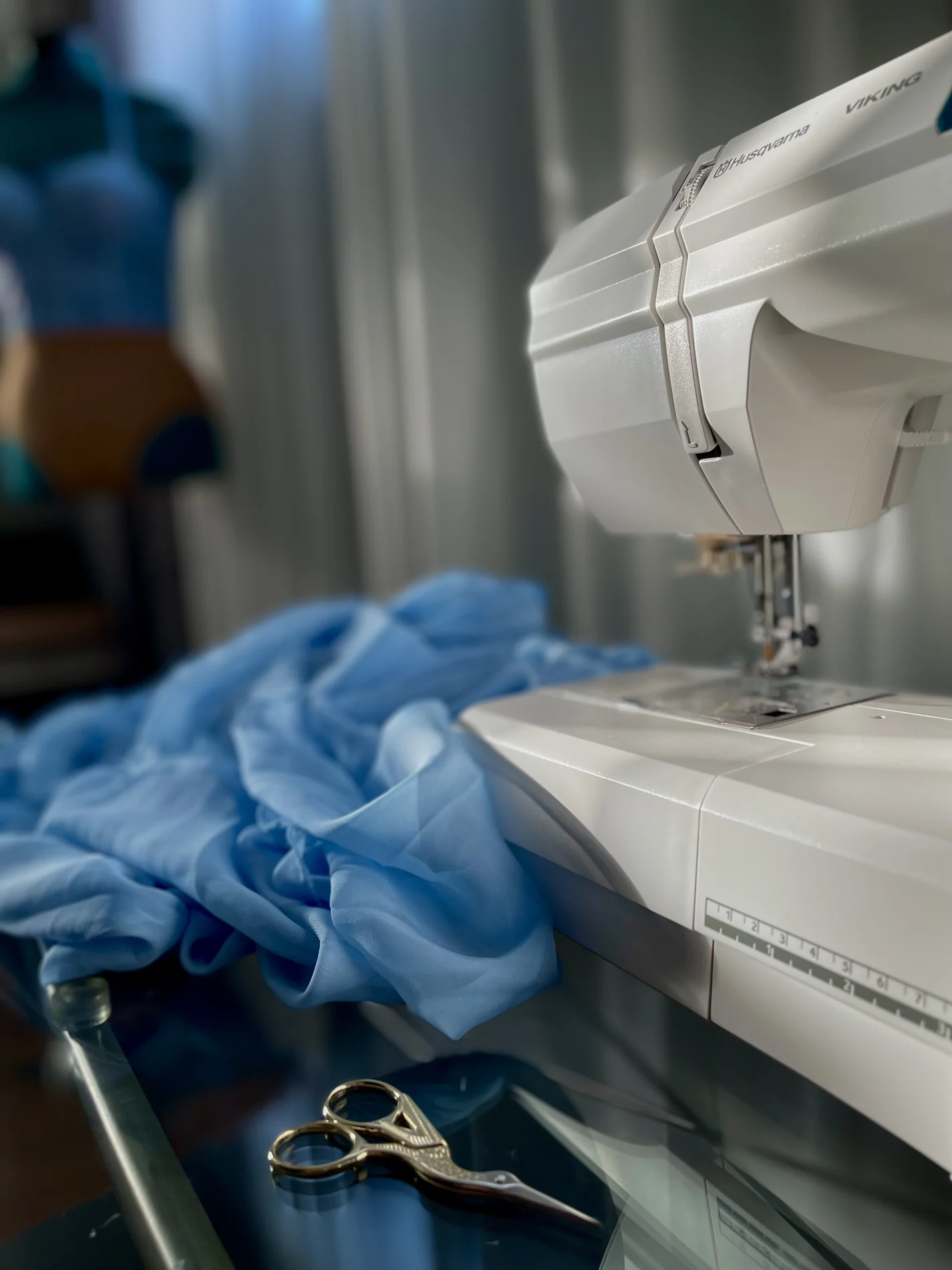 Blue fabric arranged beside a sewing machine