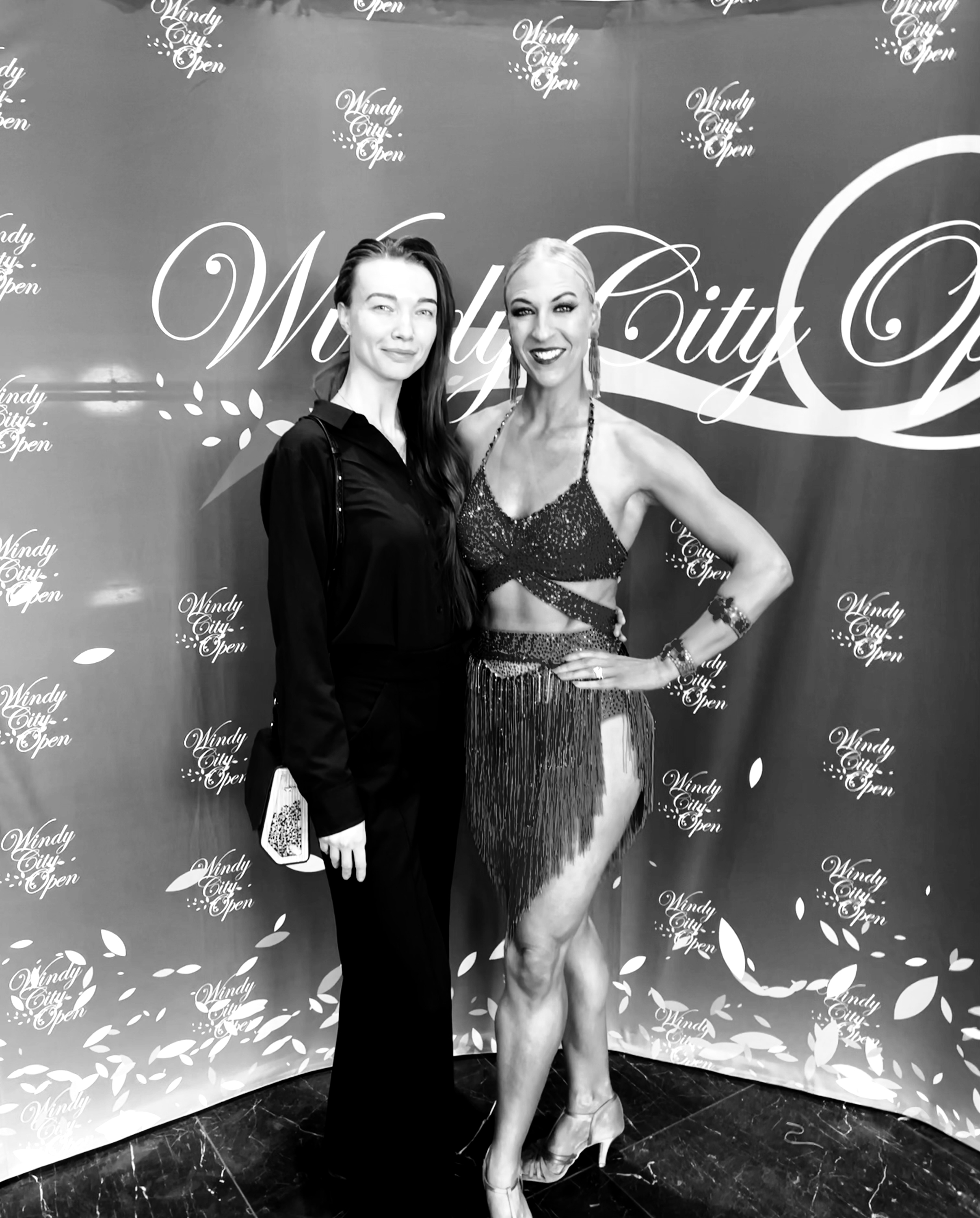 Two women posing together at a ballroom competition