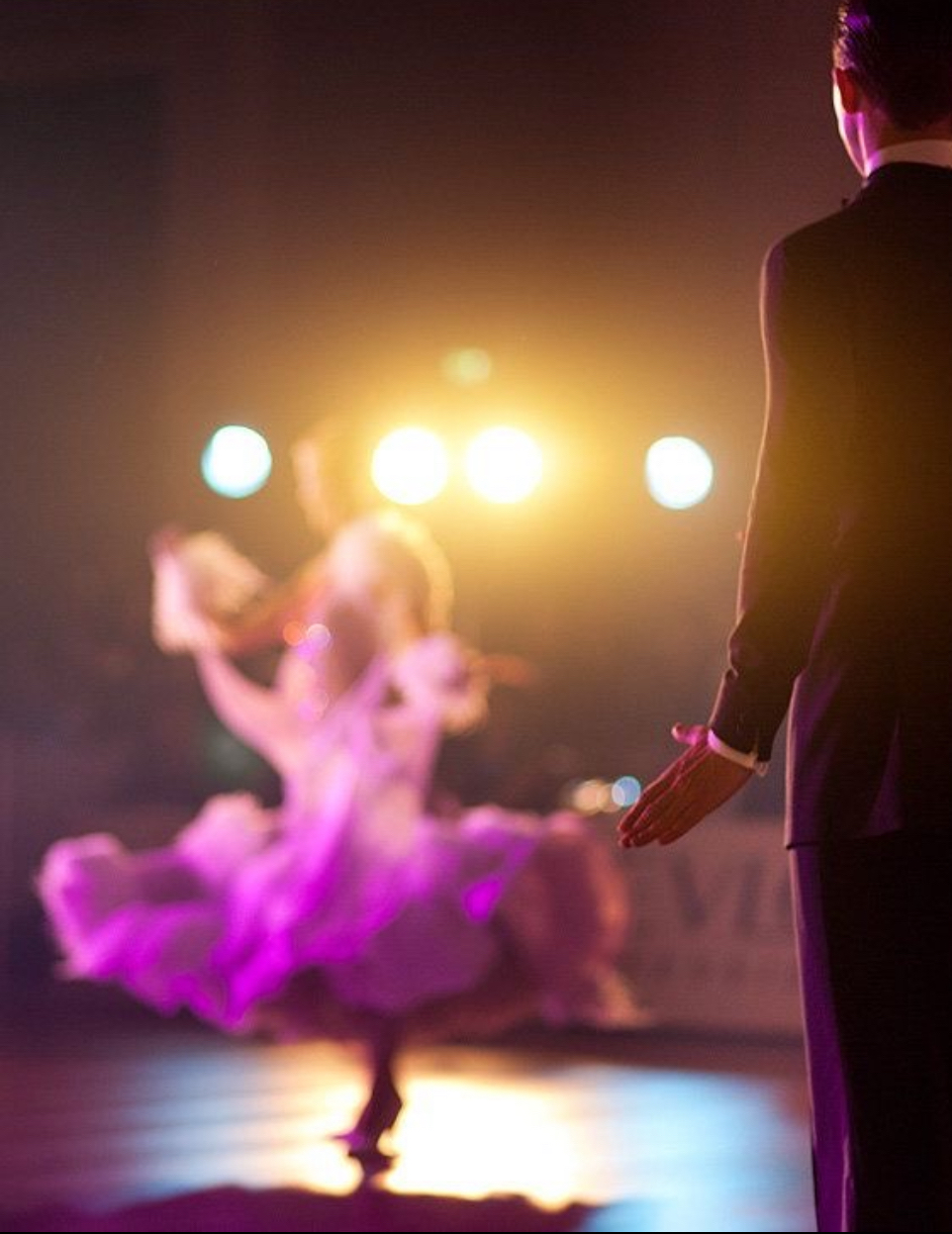 Judge watching dancers under bright competition floor lights