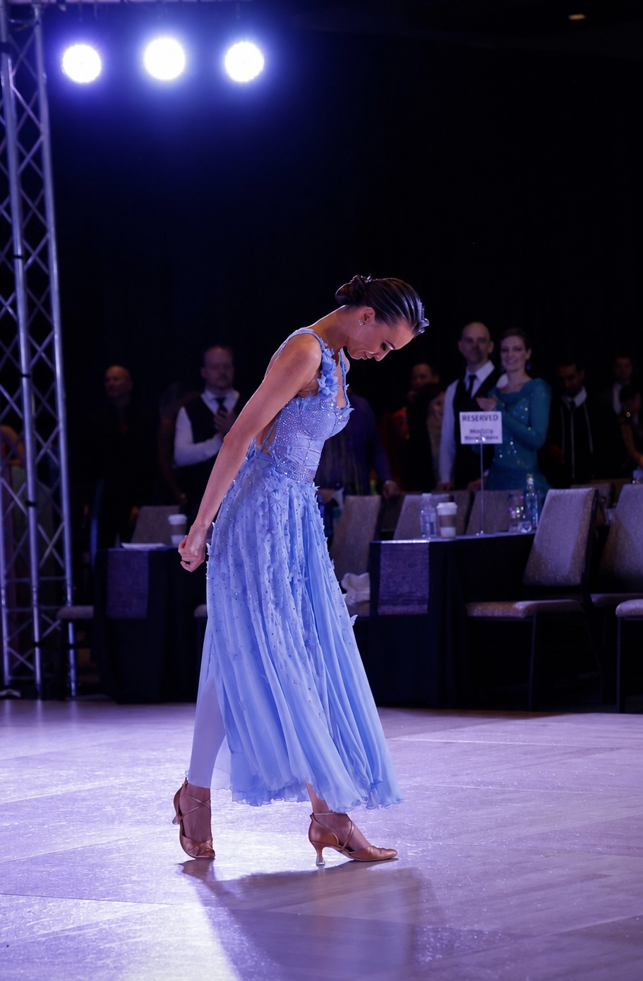 Ballroom dancer wearing the pale blue Blue Mirage gown on the competition floor